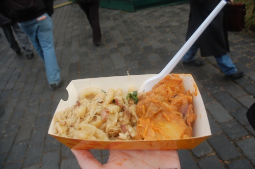 traditional Czech street food (potato dumpling pieces and sausage on the left, spicy potatoes with sauerkraut and sausage on the right)